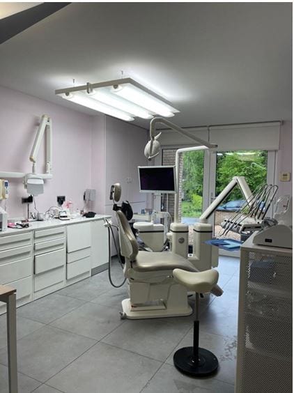 Salle de soins aux murs rose poudré ouverte sur la verdure